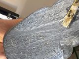 a person holding a large rock with writing on it