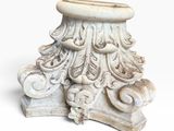a white pedestal with a flower design on it