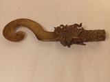 an antique brass hook with a dragon head on it
