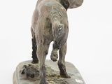 statue of a dog standing on a wooden base with a white background