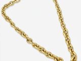 gros plan d'un collier en chaîne en or sur fond blanc