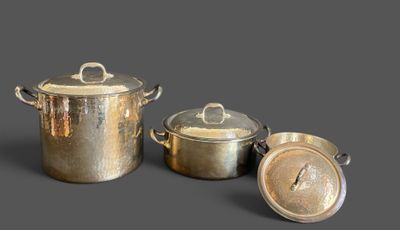 three pots and pans that are sitting on a table
