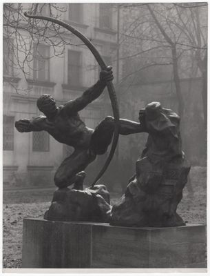 photographie en noir et blanc représentant la statue d'un homme tirant à l'arc