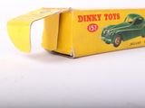a green toy car in a yellow box on a white surface