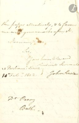 une vieille lettre portant des inscriptions, posée sur une feuille de papier