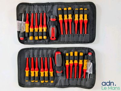 deux outils noirs et jaunes dans un étui noir posé sur une surface blanche
