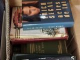 de nombreux livres dans une boîte en carton posée sur le sol