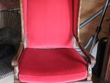 a red chair that is sitting in front of a fire place