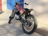 a red dirt bike parked on the side of the street