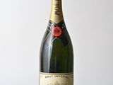 moet and chandon champagne bottle on wooden table against white wall