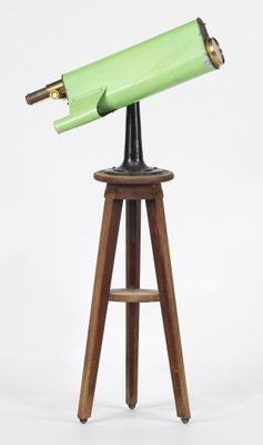 un télescope vert posé sur un trépied en bois