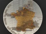 une médaille en argent et en or sur laquelle figure une carte de la France