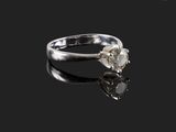 a close up of a diamond ring on a black surface