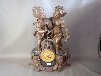 une horloge sur laquelle est représentée une statue de deux chérubins