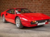 a red sports car parked in front of a brick wall