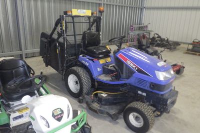 deux tondeuses à gazon et un tracteur dans un garage