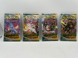 Quatre paquets de cartes à collectionner Pokémon sont alignés sur une table