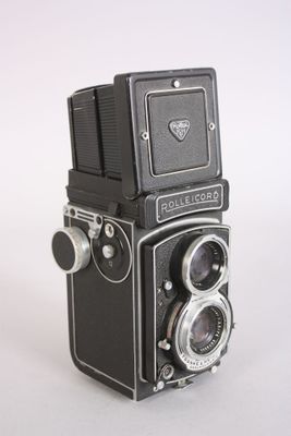 a black and silver camera sitting on a white surface