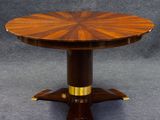 une table de salle à manger ronde avec un plateau en bois et des finitions en laiton