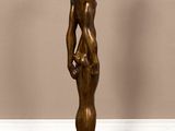 the statue is standing on a wooden base in a room