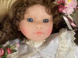 a doll that is wearing a hat with flowers on it