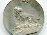 an old silver coin with a lion on it on a white surface