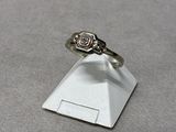 silver ring with a diamond on top of a small white pyramid