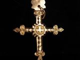 un gros plan d'une croix en or sur laquelle figure une flèche