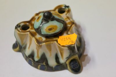 une petite tortue en céramique avec une étiquette autour du cou