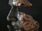 a close up of a sculpture of a man ' s face with his hand on his chin