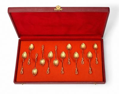 un lot de six cuillères en or dans un coffret rouge