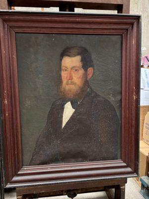 portrait d'un homme barbu portant un nœud papillon, dans un cadre en bois