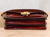 a brown purse sitting on top of a wooden table