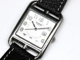 a black and white photo of a watch on a white surface