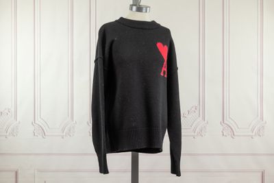 un pull noir avec un oiseau rouge sur la poitrine