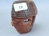 un petit masque en bois muni d'une étiquette