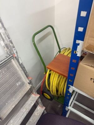 a ladder and a cart in a room with a lot of boxes
