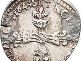 a close up of a silver coin with a cross on it