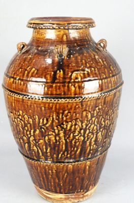 un vase brun posé sur une surface blanche
