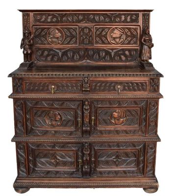 un vieux meuble en bois avec des sculptures et des gravures sur le dessus