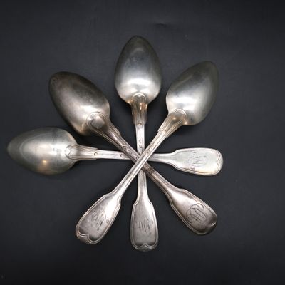 five spoons arranged in a circle on a black surface