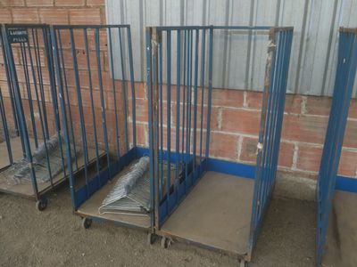 trois cages métalliques surmontées d'un matelas, devant un mur de briques