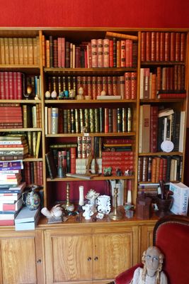 une chaise rouge devant une bibliothèque remplie de livres