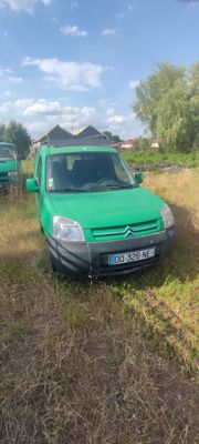 une camionnette verte garée dans l'herbe