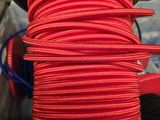 a close up of a spool of red rope on a table