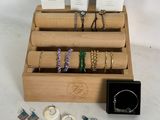 a wooden display case with a variety of jewelry on it