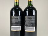 two bottles of wine sitting next to each other on a table