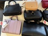 a lot of purses sitting on a table in a room