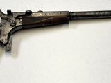 un vieux pistolet posé sur une surface blanche
