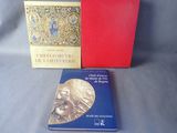 Deux livres sont posés sur une table, à côté d'une boîte rouge.